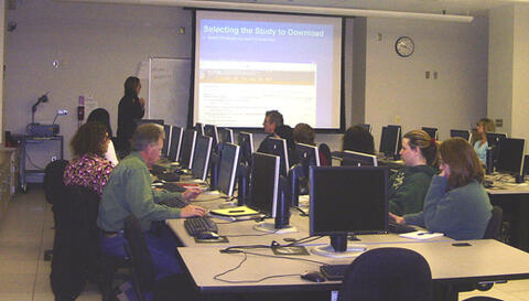 People at a conference sitting round a table with computers