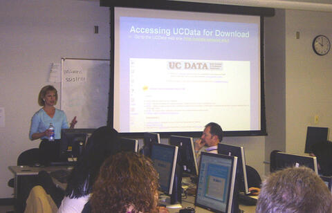 Presenter at a conference with attendees sitting at computers